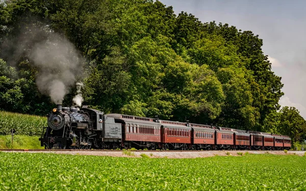 Veduta di un antico treno passeggeri restaurato a vapore che soffia fumo — Foto Stock