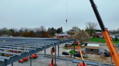 Gordonville, Pennsylvania, 10 Nisan 2025 işçiler banliyödeki bir inşaat alanında malzeme taşımak için vinç kullanıyorlar. Bulutlu hava ilerlemeyi durdurmaz. Ekipman yerleştirildi ve