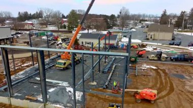 Gordonville, Pennsylvania, 25 Şubat 2026 - İşçiler kışın bir şantiyede vinç ve makine kullanırlar. İnşaat projesini tamamlamak için araçlar malzeme ve araçları hareket ettirir.