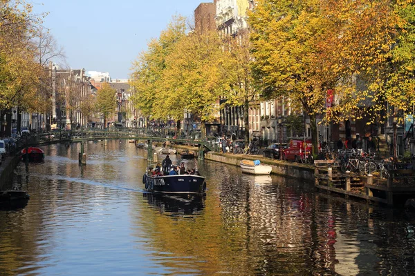 アムステルダム オランダ 2016年11月11日 人々は11月11日に歴史的なアムステルダム オランダの秋の木と運河の小さなボートで航海します — ストック写真