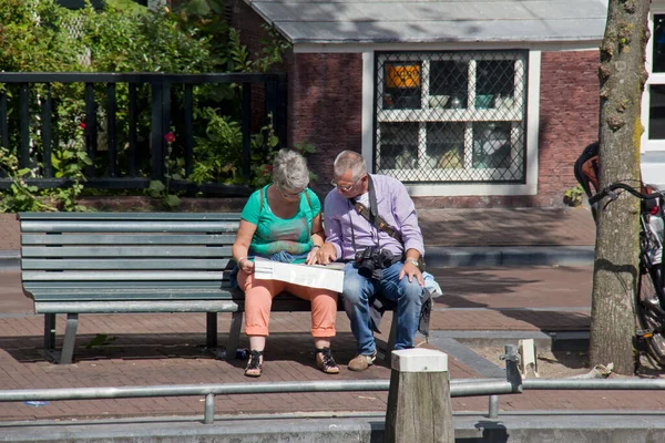 Amsterdam Augustus 2013 Twee Oudere Toeristen Zitten Een Bankje Bestuderen — Stockfoto