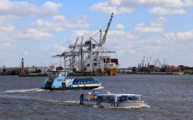 Hamburg, Almanya - 2 Temmuz 2019: Almanya 'nın Hamburg kentindeki Elbe nehri üzerinde 2 Temmuz 2019' da liman vinçleri ve feribotları