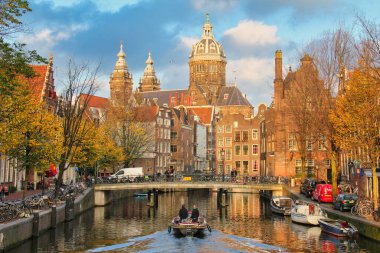 Amsterdam, Hollanda - 12 Kasım 2015: Amsterdam, Hollanda 'da 12 Kasım 2015 tarihinde, tarihi Amsterdam' da Aziz Niklas Kilisesi 'nin arka planında yer alan insanlar.