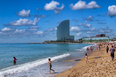 Barselona, İspanya - 23 Mayıs 2015: İnsanlar 23 Mayıs 2015 tarihinde İspanya 'nın Barselona kentinde Dünya Ticaret Merkezi ile birlikte plajda uzanır..