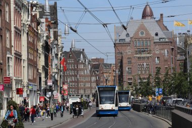 Amsterdam, Hollanda - 23 Mayıs 2019: Hollanda 'nın başkenti Amsterdam' da 23 Mayıs 2019 'da Dam Meydanı yakınlarında tramvay ve bisikletli insanlar