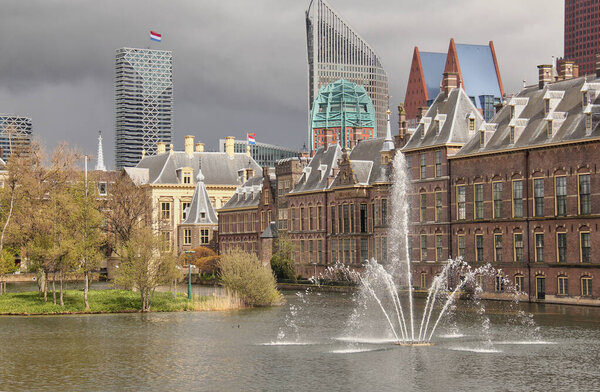 Hofvijver pond, trees, fountain and historical buildings at the Dutch Parliament Binnenhof in The Hague, The Netherlands