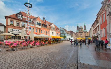 Speyer, Almanya - 2 Mayıs 2014: Turistler 2 Mayıs 2014 'te Almanya' nın Speyer kentinin eski merkezindeki tarihi binalar ve büyük katedralle çevrili ve mayıs direğiyle ana caddede yürüyorlar.
