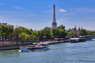 Paris, Fransa - 11 Mayıs 2018: 11 Mayıs 2018 'de Paris, Fransa' da Eyfel Kulesi 'ni geçen Seine nehri üzerinde turistlerle dolu bir tekne denize açıldı.