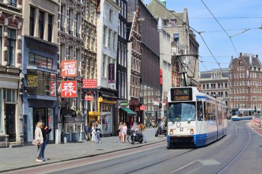 Amsterdam, Hollanda - 23 Mayıs 2019: Tramvay ve Hollanda 'nın orta kesimindeki Baraj Meydanı yakınlarında yürüyen insanlar