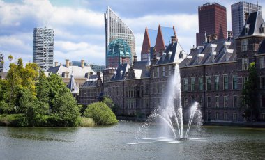 Hollanda, Lahey 'deki Binnenhof parlamento binalarındaki Hofvijver göletindeki çeşme ve ağaçlar 