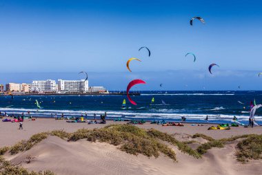 El Medano, Tenerife, İspanya, Mart 01, 2026: Uçurtmacılar ve rüzgar sörfçüleri El Medano plajının kumlu kumullarında şiddetli rüzgarların tadını çıkarıyorlar. Kanarya Adaları 'nın Atlantik kıyısındaki popüler su sporları.