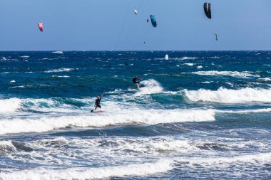 El Medano, Tenerife, Kanarya Adaları, İspanya 01.03.2026: El Mdano sahilinde Atlantik Okyanusu 'nda dalgalar üzerinde sörf yapan uçurtma sörfü yapan ünlü bir rüzgar sörfü ve uçurtma rotası..