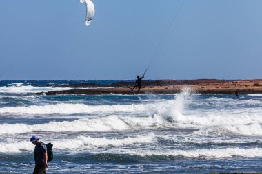 El Medano, Tenerife, Kanarya Adaları, İspanya 01.03.2026: Atlantik Okyanusu 'ndaki El Mdano sahilinde dalgalarda sörf yapan uçurtma sörfçüleri, ufukta renkli yelkenlerle ünlü bir rüzgar sörfü ve uçurtma rotası..
