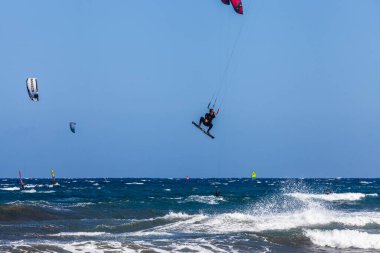 El Medano, Tenerife, Kanarya Adaları, İspanya 01.03.2026: Atlantik Okyanusu 'ndaki El Mdano sahilinde dalgalarda sörf yapan uçurtma sörfçüleri, ufukta renkli yelkenlerle ünlü bir rüzgar sörfü ve uçurtma rotası..