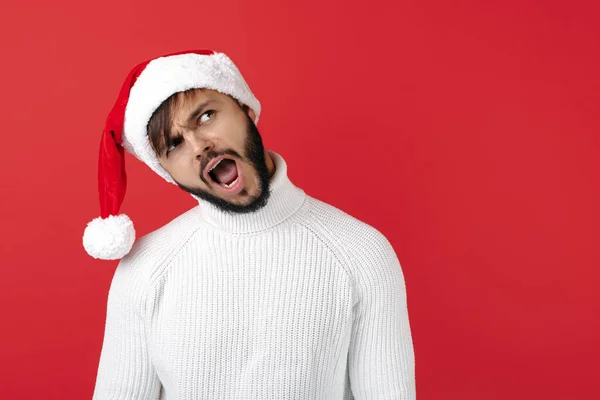 Homem hipster alegre usa chapéu de Papai Noel sobre fundo vermelho. Conceito de Natal e Ano Novo. — Fotografia de Stock
