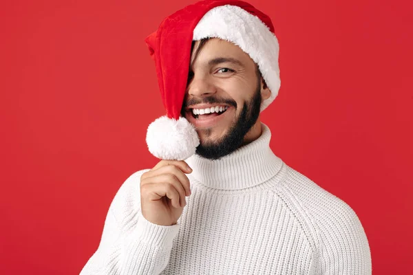 Bonito hipster usa chapéu de Pai Natal sobre fundo vermelho. Conceito de Natal e Ano Novo. — Fotografia de Stock