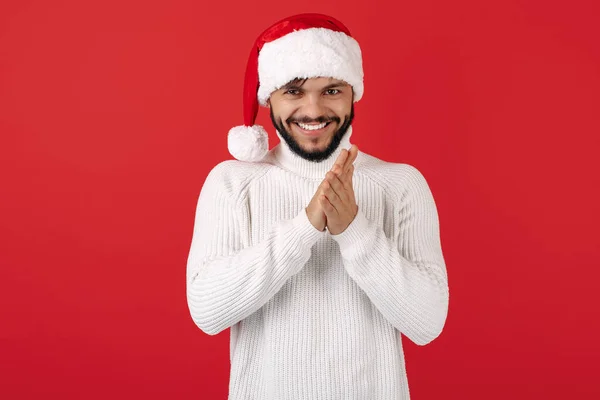 Leery hipster homem usa chapéu de Papai Noel sobre fundo vermelho. Conceito de Natal e Ano Novo. — Fotografia de Stock