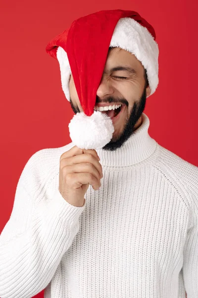 O hipster encantado usa chapéu de Pai Natal sobre fundo vermelho. Conceito de Natal e Ano Novo. — Fotografia de Stock