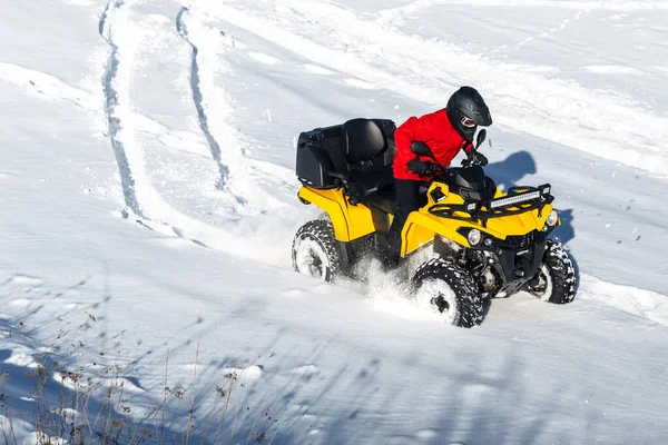 若いです男ドライバー運転彼のATV 4wdクワッドバイクスタンドで大雪とともに深いホイールトラック. — ストック写真