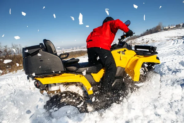 極端なドライバーは深いホイールトラックと大雪の中で彼のATV 4wdクワッドバイクスタンドを運転. — ストック写真