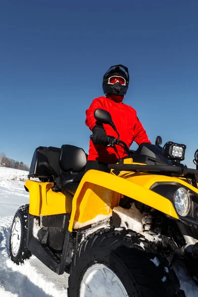 ATVクアッドバイクの若い男ドライバーのクローズアップ画像は、深いホイールトラックと大雪の中に立っています。元ウィンタースポーツ. — ストック写真