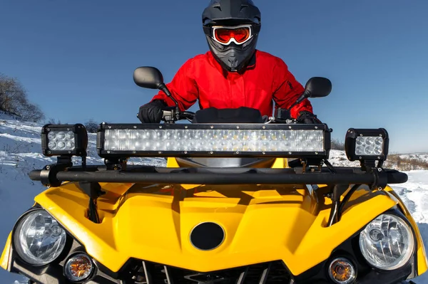 Крупный план экстремальный водитель за рулем квадроцикла ATV стоять в тяжелом снегу с глубоким колесом. — стоковое фото