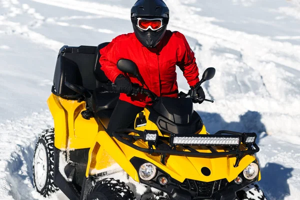 Γκρο πλαν εικόνα του νεαρού άνδρα ακραίο οδηγό για το ATV quad ποδήλατο σταθεί σε βαρύ χιόνι με βαθιά τροχιά τροχό. — Φωτογραφία Αρχείου