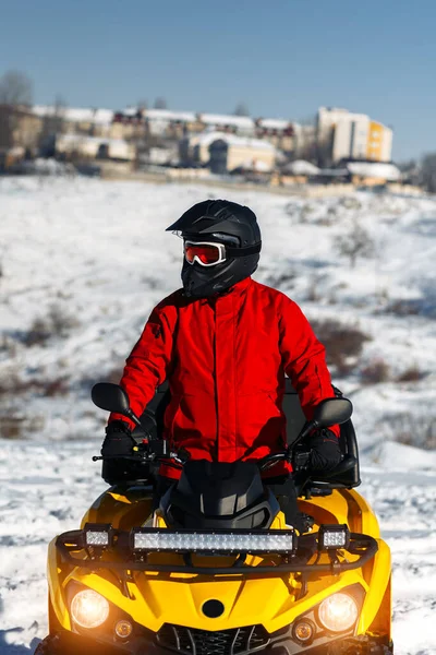 ATVクアッドバイクの若い男ドライバーのクローズアップ画像は、深いホイールトラックと大雪の中に立っています。元ウィンタースポーツ. — ストック写真