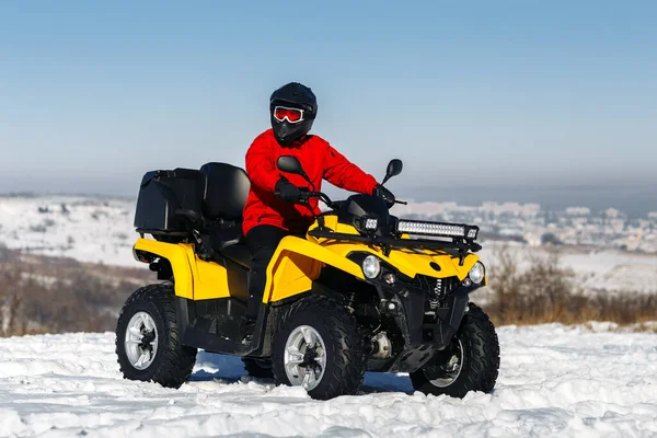 ATVクワッドバイクの若い男ドライバーは深いホイールトラックと大雪の中に立つ。元ウィンタースポーツ. — ストック写真