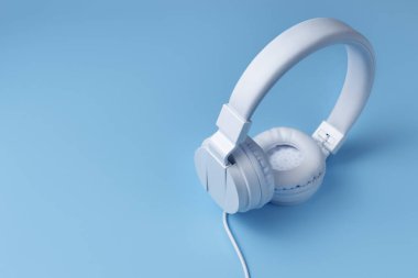 Mavi arka planda beyaz kulaklık. Müzik konsepti.