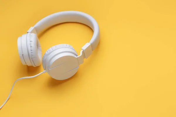 黄色背景的现代白色耳机。音乐概念. — 图库照片