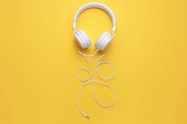Sarı arka planda modern beyaz kulaklık. Müzik konsepti.