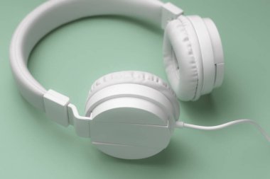 Cyan arka planında modern beyaz kulaklığın yakın plan görüntüsü. Müzik konsepti.