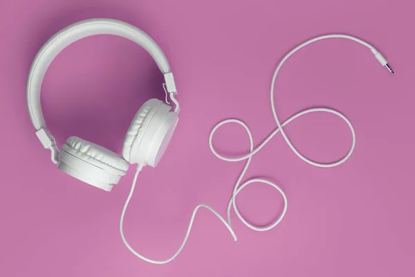 Cool witte koptelefoon op roze achtergrond. Muziekconcept. — Stockfoto