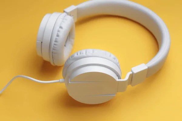 Moderní bílé sluchátka na žlutém pozadí. Hudební koncept. — Stock fotografie