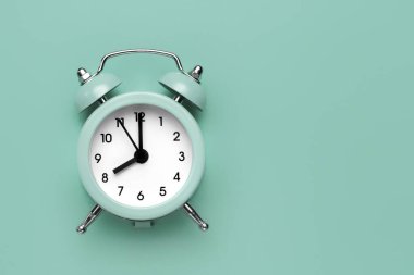 Nane yeşili zemin üzerinde klasik yuvarlak alarm saati.