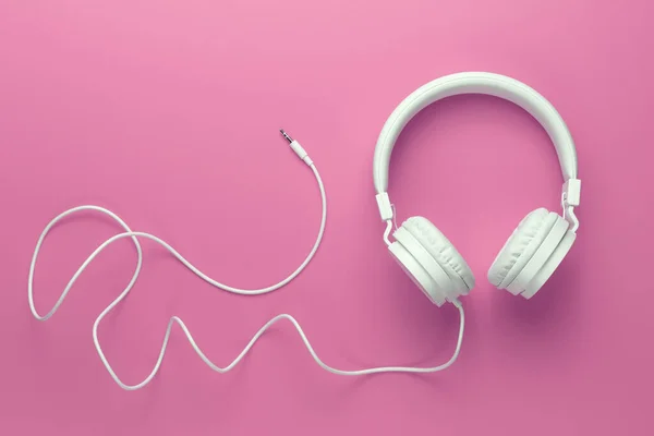 Moderne witte koptelefoon op roze achtergrond. Muziekconcept. — Stockfoto
