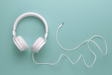 Cyan arka planda modern beyaz kulaklık. Müzik konsepti.