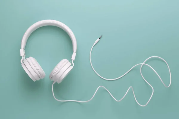 Moderní bílé sluchátka na azurovém pozadí. Hudební koncept. — Stock fotografie