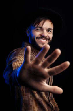 Siyah arka planda kahverengi gömlekli yakışıklı, sakallı hippi..