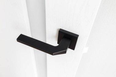 Yakından bakınca şık İskandinav beyaz kapısı antrasit kapı kolu ve minimalist cam şeritli..