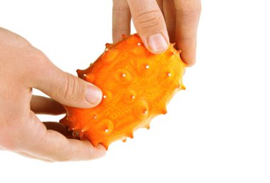 Salatalık metuliferus ya da beyaz arka planda izole edilmiş boynuzlu kavun. Erkeklerin ellerinde tek bir Afrika boynuzlu salatalığı. Seçici odaklanma..