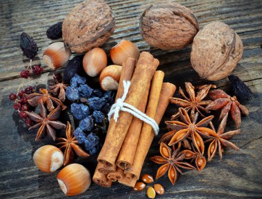 Baharatlar tarçın, anason yıldızları, yakınlarda kuru üzümler, ahşap bir arka planda..