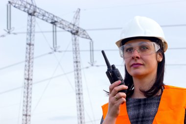 Electrical distribution engineer talking on a walkie- talkie clipart