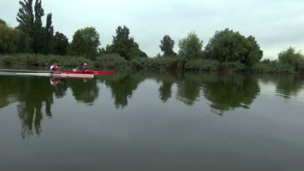 Jóvenes miembros del equipo entrenando en un kayak — Vídeos de Stock