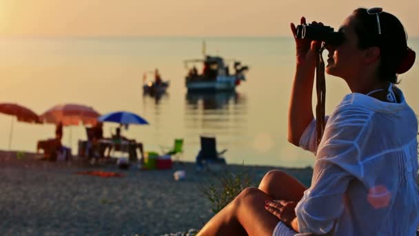 Chica con prismáticos en la playa — Vídeos de Stock