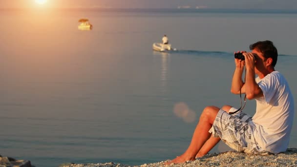 Man with binoculars on the sea shore — Stock Video