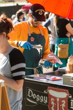 Satıcı sosisli sandviç Atlanta Festivali'nde lahana turşusu koyar