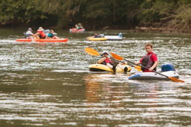 İnsanlar Sal ve sıcak yaz gününde Nehri boyunca Kayak