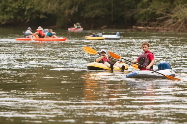 La gente balsa y kayak a lo largo del río en el día caliente de verano —  Fotos de Stock